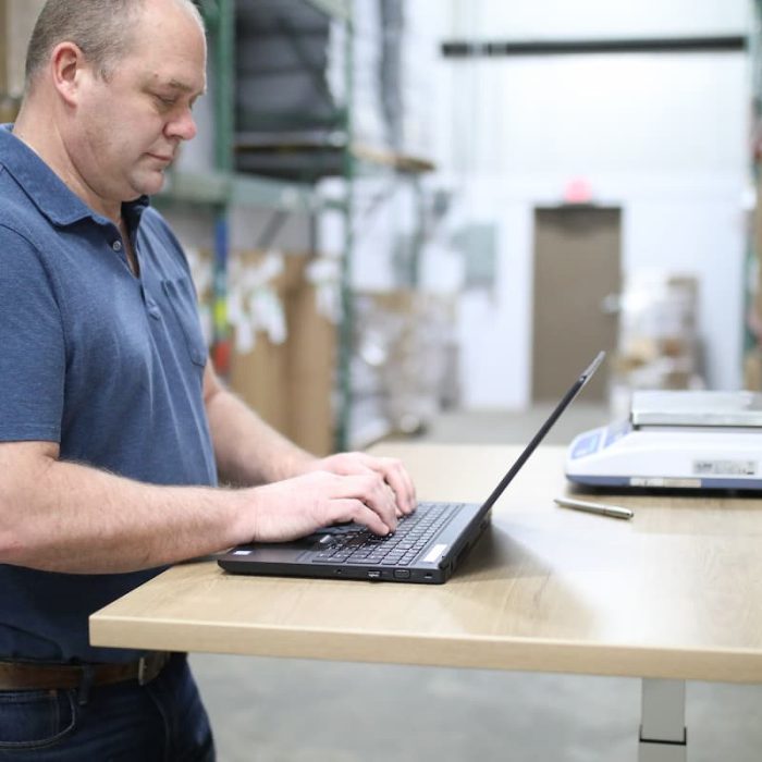 A person in a warehouse using a laptop
