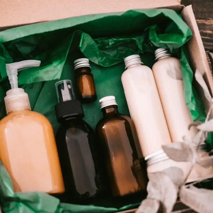 Beauty box with bottles of natural cosmetics, wrapped in green paper. Blogger hair and body care routine, salon treatments